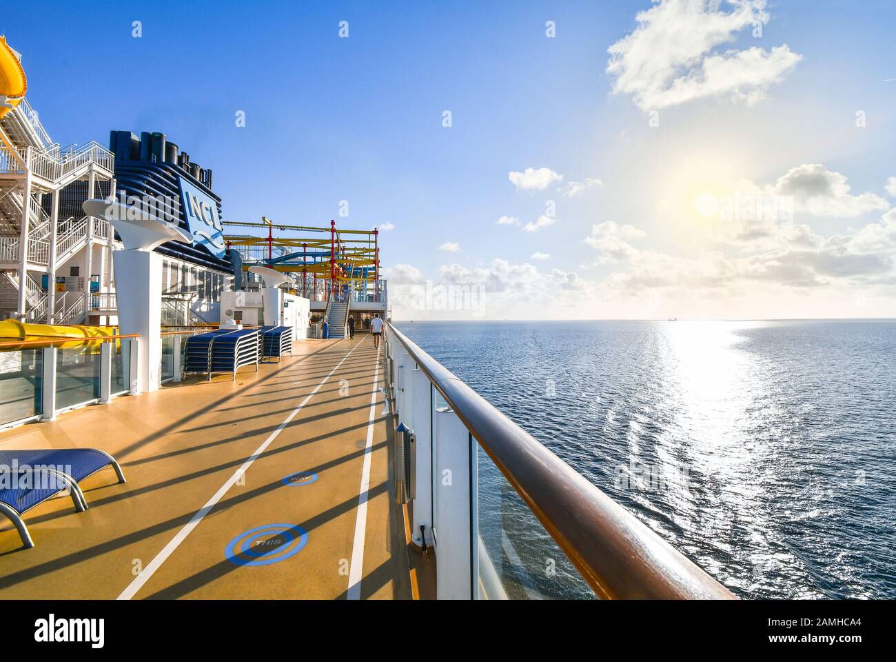 Ein Kreuzfahrtpassagier nutzt den Jogging- und Gehweg auf einem Luxuskreuzfahrtschiff mit einem Schiff in der Ferne auf der Ostsee. Stockfoto
