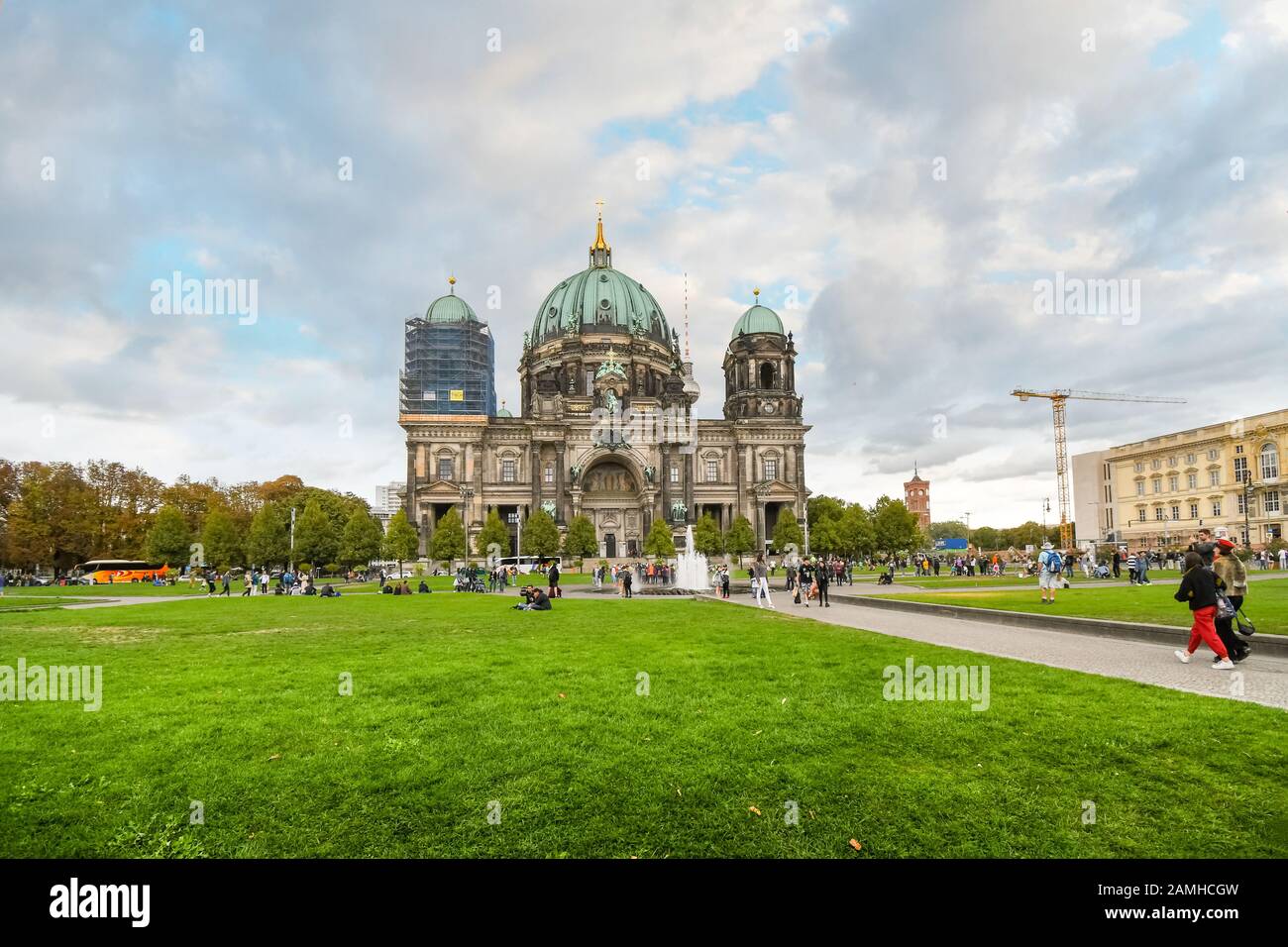 Die Frontfassade des Berliner Doms, wie sich die Öffentlichkeit im Lustgarten an einem teilweise bewölkten Tag im Spätsommer versammelt. Stockfoto