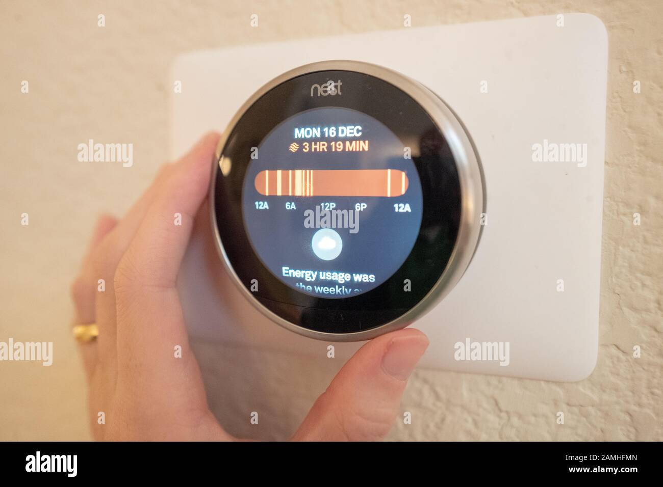 Nahaufnahme eines Mannes, der einen Bericht über Den Einsatz Künstlicher Intelligenz auf einem Nest Learning Thermostat, einem Internet of Things Gerät von Google Inc, in einem intelligenten Haus in San Ramon, Kalifornien, am 17. Dezember 2019 überprüft. () Stockfoto