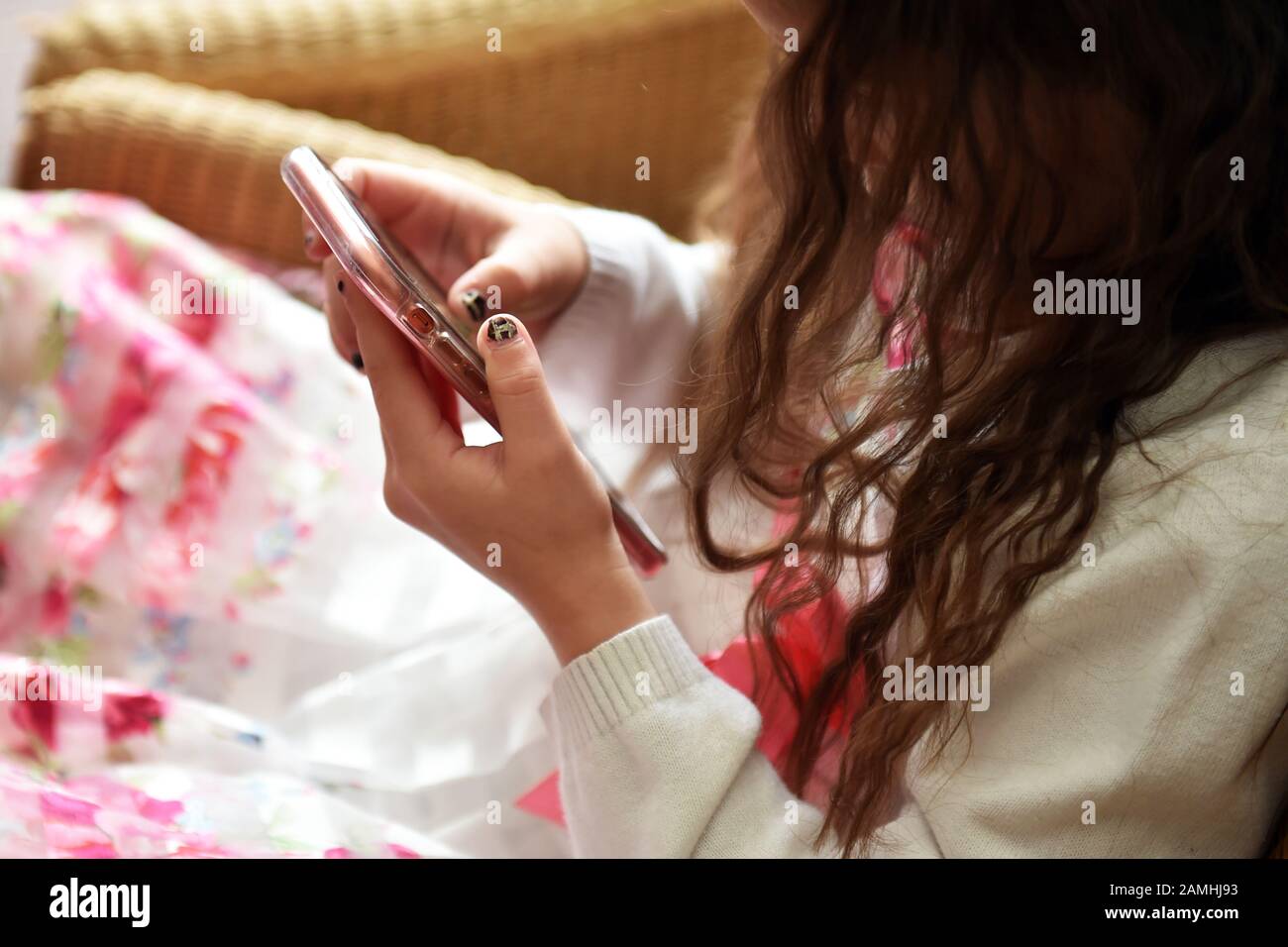 Junge Mädchen spielt auf einer Party auf ihrem Handy. Stockfoto