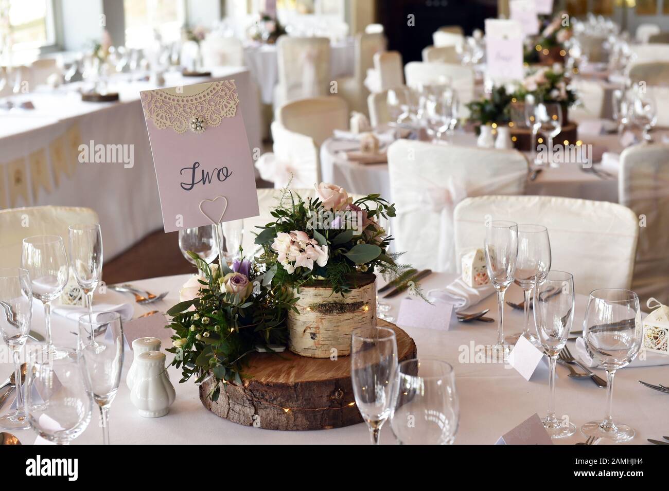 Hochzeitstisch mit Holztablett und Blumen. Stockfoto