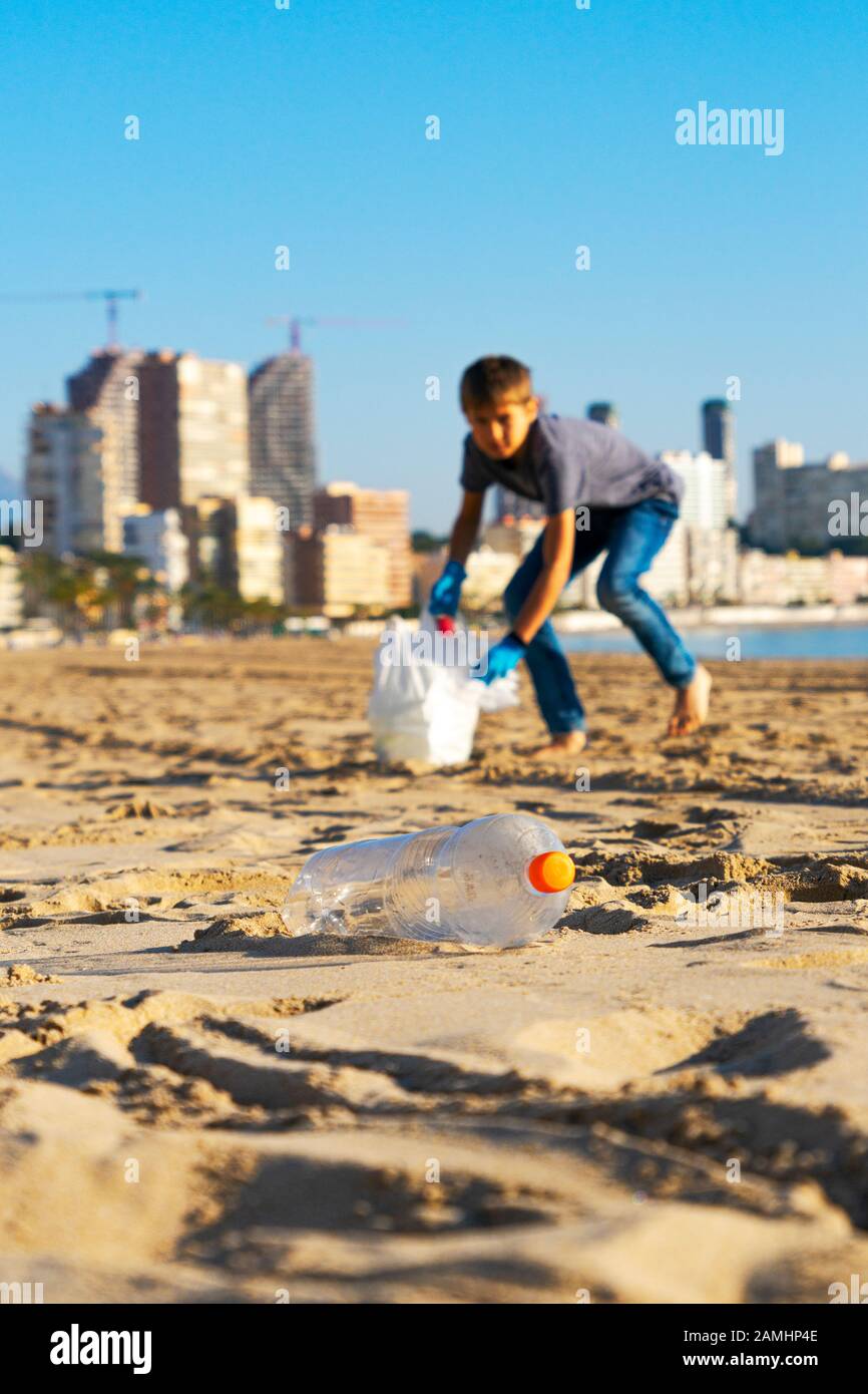 Reinigung Stadt Strand aus Kunststoff Papierkorb. Kid Abholung Plastikflasche Papierkorb vom Strand und in Plastikbeutel für Recycling Stockfoto
