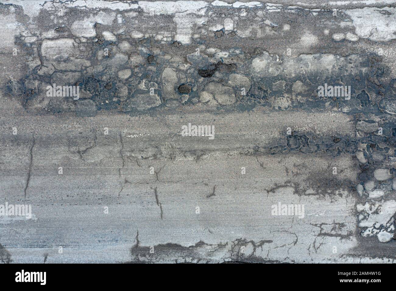 Große Gruben werden mit Wasser auf eine Asphaltstraße gefüllt Stockfoto