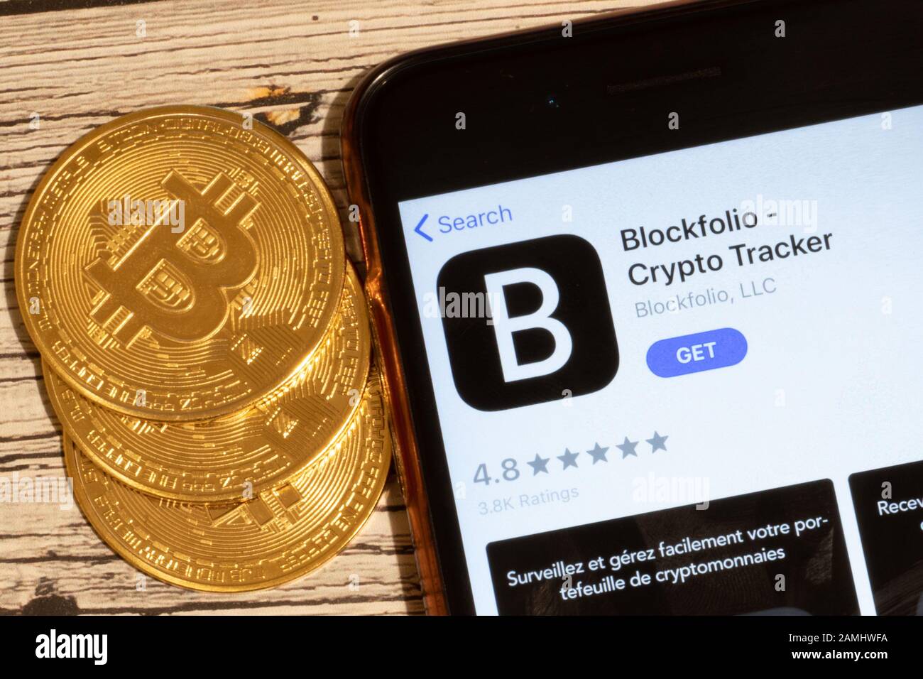 Sankt Petersburg, Russland - 10. Januar 2020: Telefonbildschirm mit BlockFolio Crypto Tracker Mobile-App-Logo Nahaufnahme mit Bitcoin-Münzen, Illustration Stockfoto