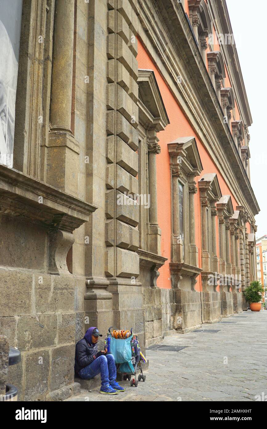 Ein Straßenhändler, der Sonnenschirme vor dem Archäologischen Nationalmuseum in Neapel in Italien verkauft Stockfoto