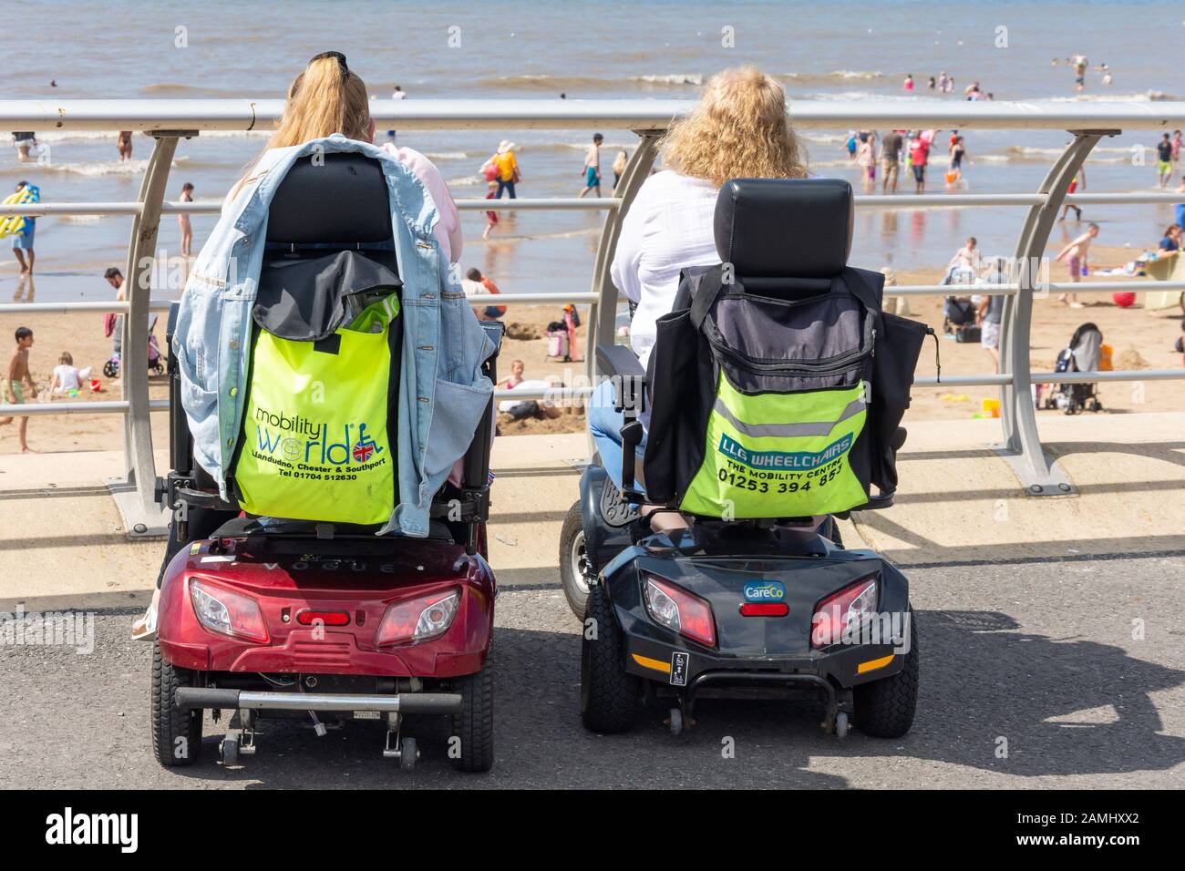 Frauen in Mobilitäts-Rollern an Strandpromenade, Blackpool, Lancashire, England, Großbritannien Stockfoto