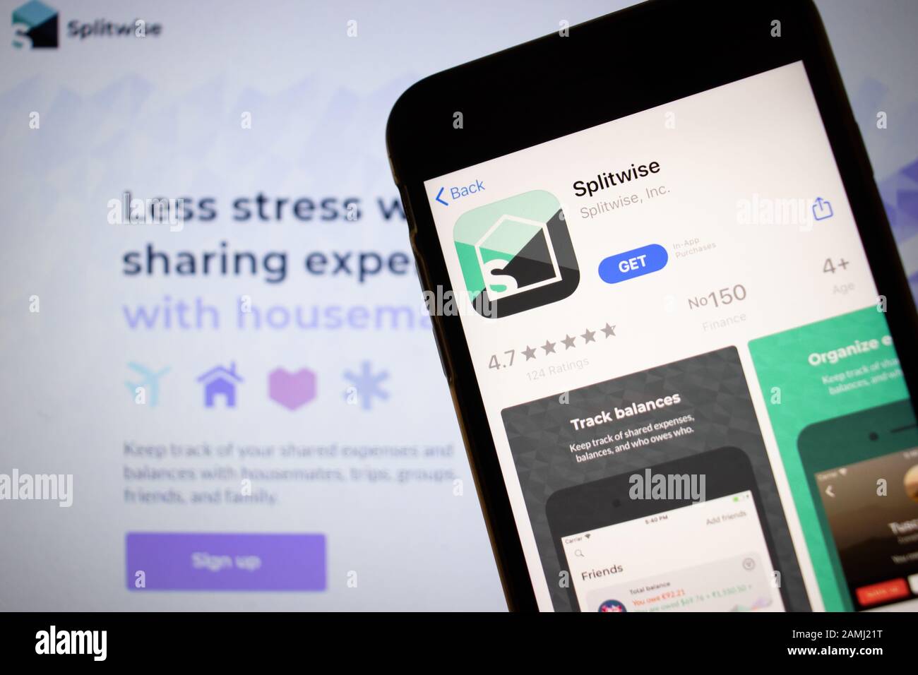 Sankt Petersburg, Russland - 10. Januar 2020: Mobiltelefon mit Splitwise Symbol auf dem Bildschirm Nahaufnahme mit Website auf Laptop, Illustrative Editorial Stockfoto