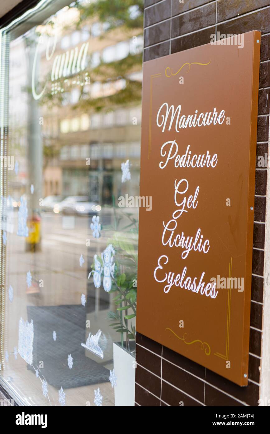 Schild außerhalb einer Nagelsalonbar mit Maniküre, Pediküre, Gelnägeln, Acrylnägeln und Wimpern. Stockfoto