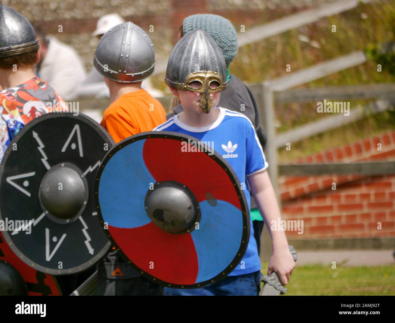 Kinder, die einen Kampf zwischen Wikingern und Sachsen bei einem Bildungs-Living-Geschicht-Event umspielen Stockfoto