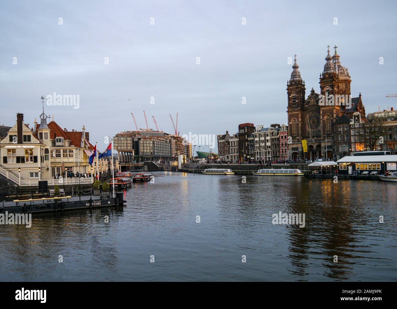 Hauptbahnhof Amsterdam und Boote auf dem Kanal Stockfoto