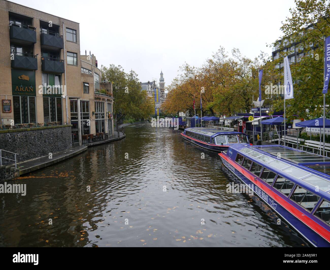 Touristenboote an einem Kanal im Zentrum von Amsterdam, Niederlande Stockfoto