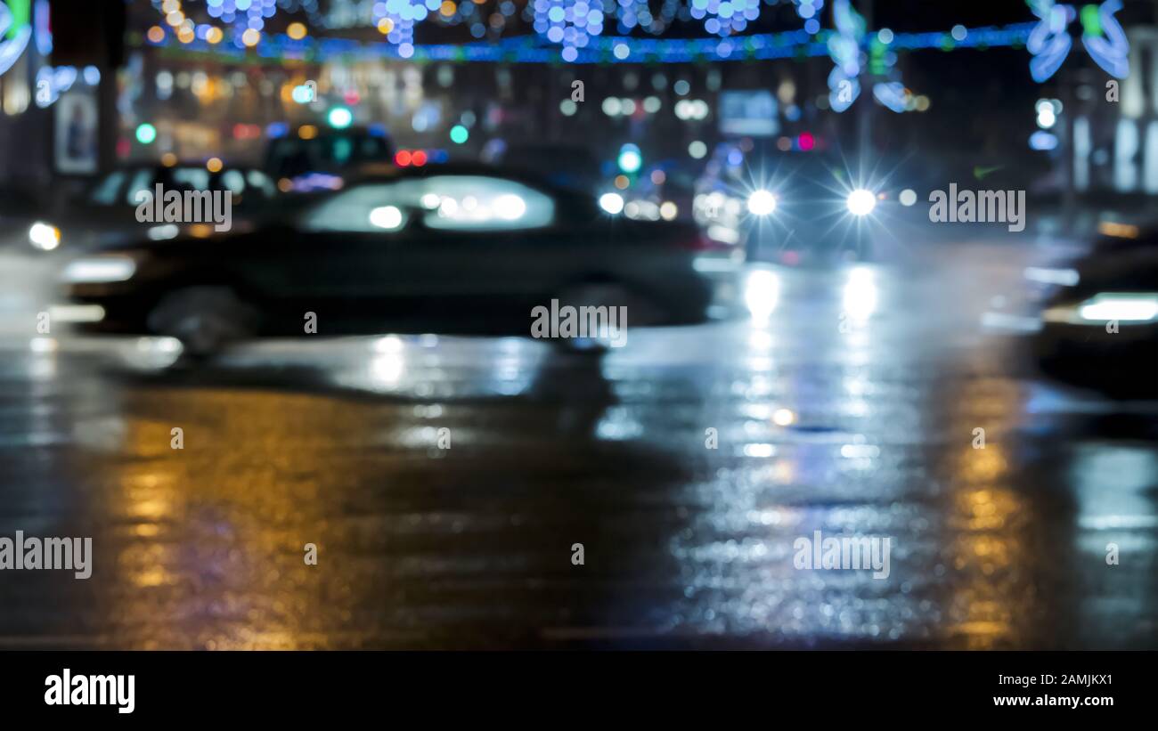 Auto auf nasser Straße, nachts verschwommener Verkehr Stockfoto