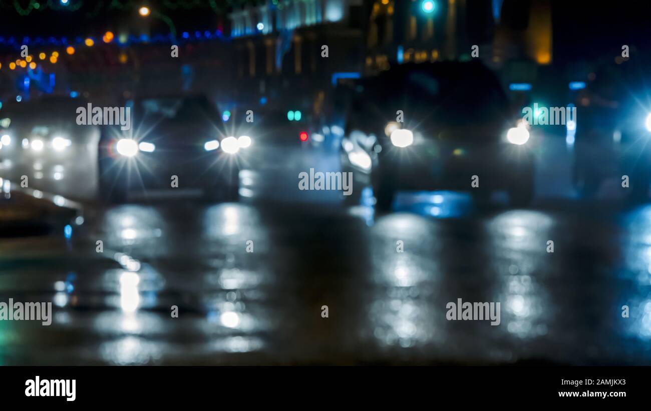 Auto auf nasser Straße fahren, nachts in der Stadt verwackelt Stockfoto