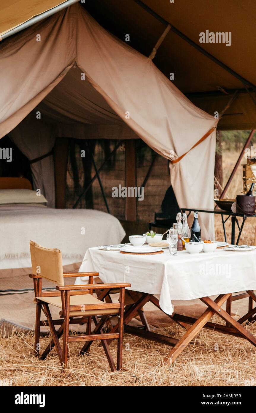 Juni 2011 Serengeti, Tansania - Luxury Safari Zeltlager mit Picknicktisch in Serengeti Savanna Forest Grumeti Reservespiel-Drivebereich - Glamping t Stockfoto