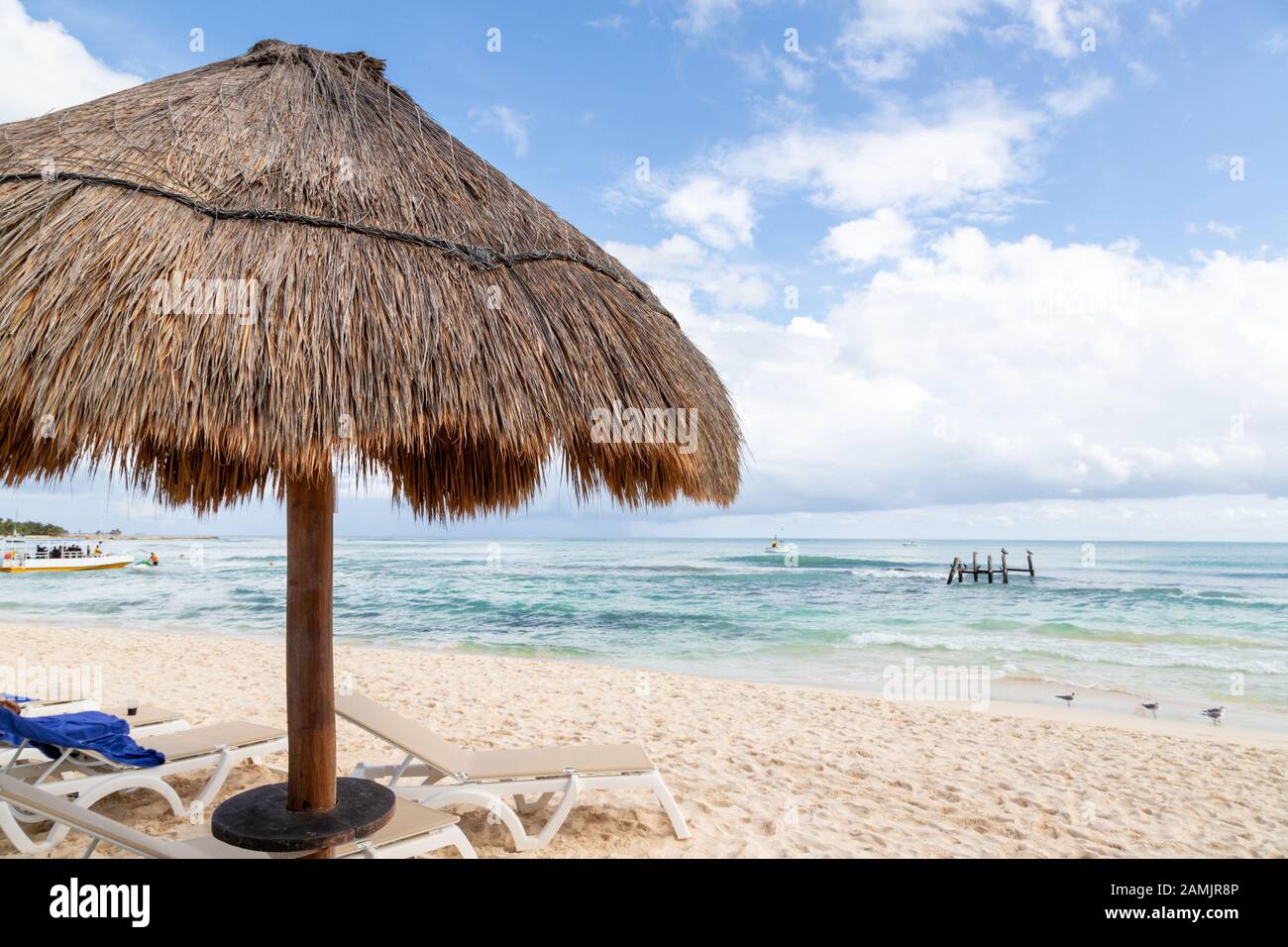 Nahaufnahme des Sonnenschirms aus Kokospalmblatt mit blauem Himmel und Kopierraum an einem Strand in Cancun in Mexiko. Stockfoto