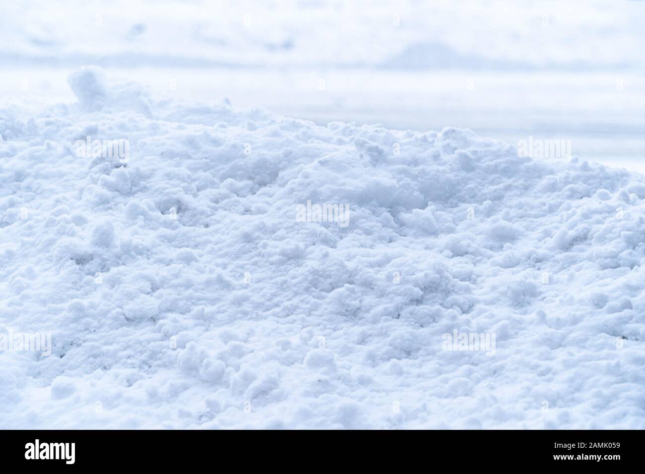 Der dicke Haufen weißer Weichschneedecken bedeckt die Betonwand Stockfoto