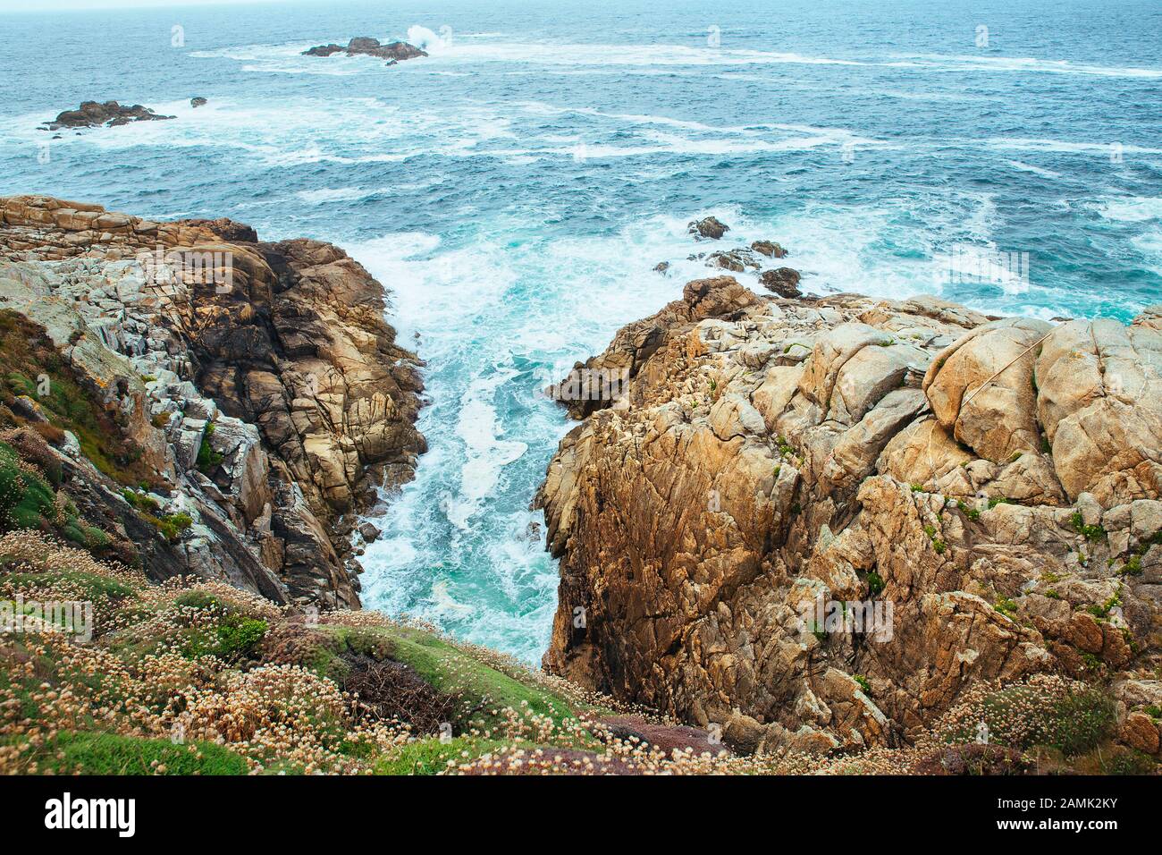 Meereswellen, die auf den Felsen einer Klippe in einer Coruna, spanien, brechen Stockfoto