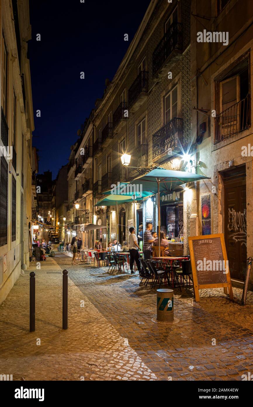 Nur wenige Menschen und Restaurants auf dem schmalen Rua Gremio Lusitano Fußgängerzone im Stadtteil Bairro Alto in Lissabon, Portugal, am Abend. Stockfoto