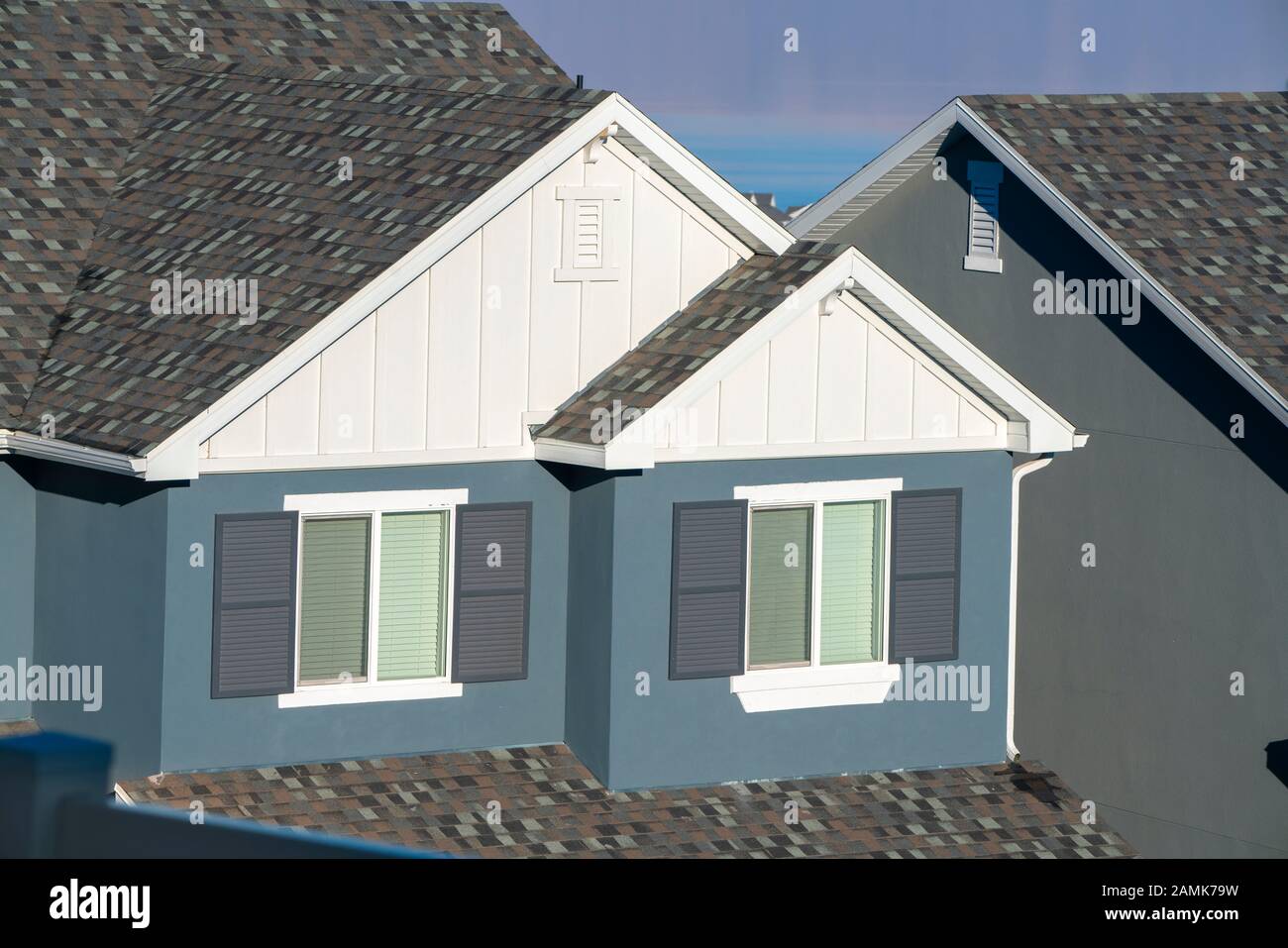 Grau-weiße Hausfassade mit Fensterläden Stockfoto