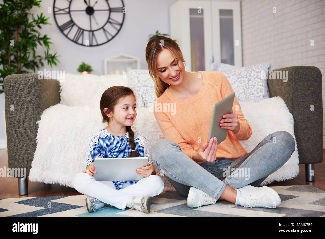 Mutter und ihr Kind, die auf ein digitales Tablet blicken Stockfoto