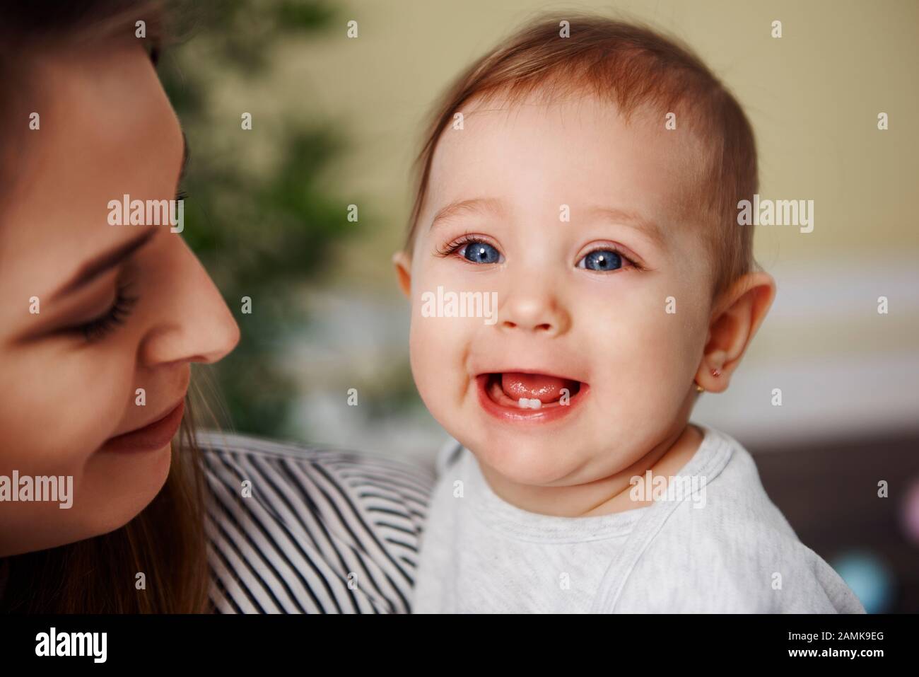 Süßes Baby-Mädchen, das ihre primären Zähne zeigt Stockfoto
