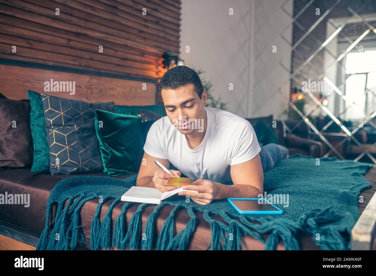 Der Typ, der mit einem Stift in einem Notizbuch schreibt. Stockfoto