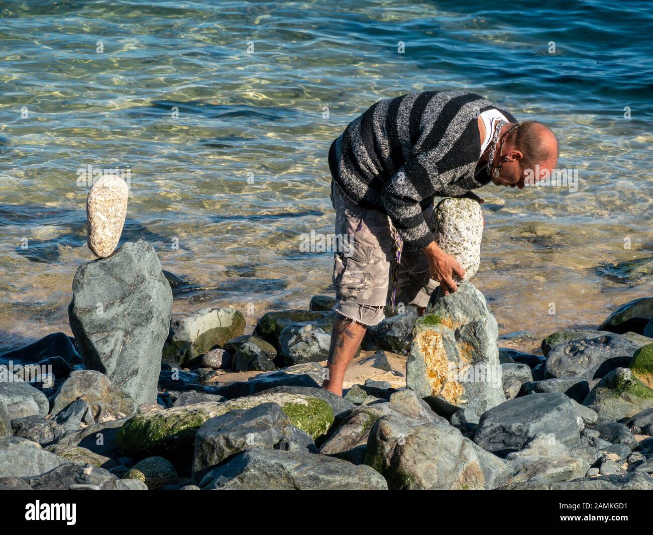 Balanced Rock artist Erstellen ausgewogene Skulpturen aus Stein unser Strand Kies auf St Ives, Cornwall, England, Großbritannien Stockfoto