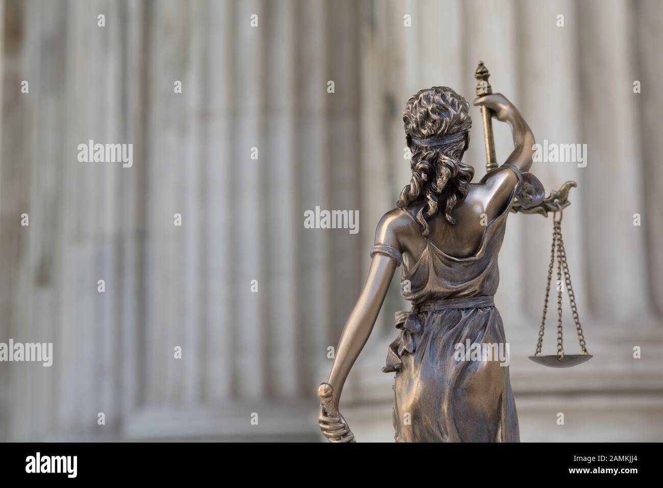 Die Statue des Gerichtshofs Themis oder Justitia mit verbundenen Augen, die Göttin der Gerechtigkeit gegen eine ionische Ordnung Kolonnade, als juristischen Begriff Stockfoto