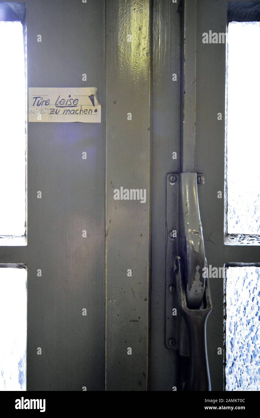 Tür am Krematorium auf dem Ostfriedhof-Friedhof mit dem handschriftlichen Schild "Türe leise schiessen". [Automatisierte Übersetzung] Stockfoto