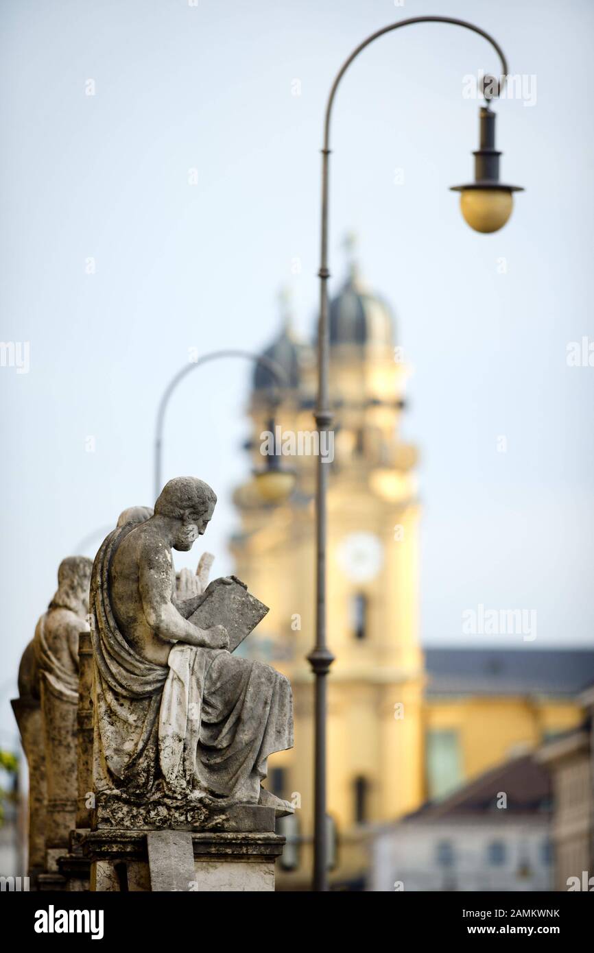 Statuen von Altertumswissenschaftlern vor der Bayerischen Staatsbibliothek in München. Im Hintergrund die Theatinenkirche. [Automatisierte Übersetzung] Stockfoto