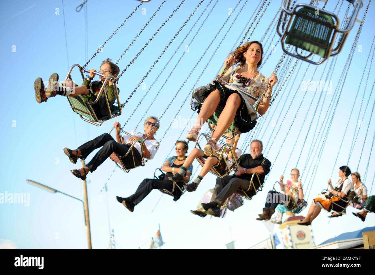 Oktoberfestbesucher im Kettenkarussell auf der Oidn Wiesn. [Automatisierte Übersetzung] Stockfoto