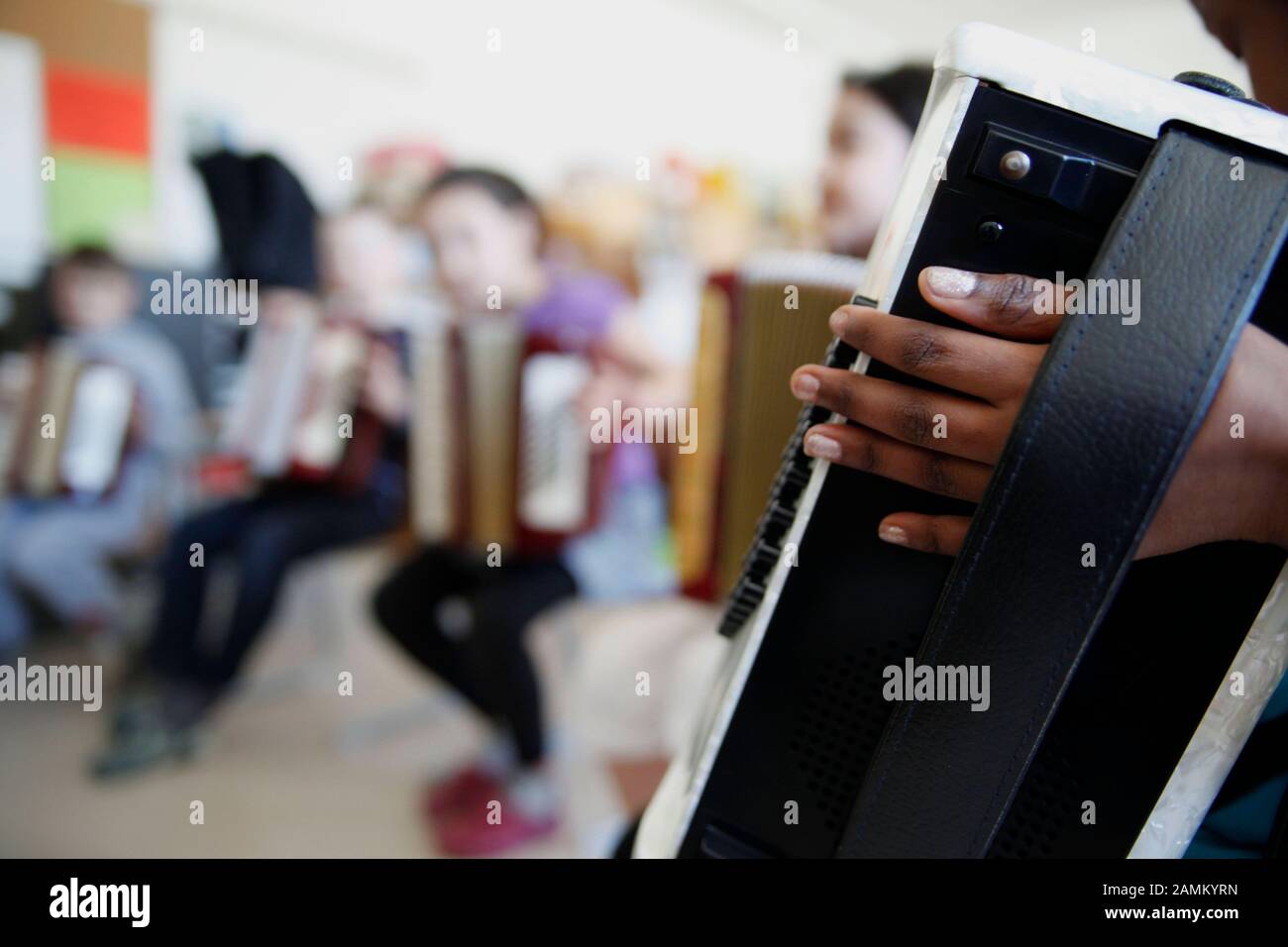 Ein Schüler übt im Rahmen des Musikschulprojekts "Ikarus" auf einem Akkordeon. Im Projekt der städtischen Gesangs- und Musikschule können Zweitklässler an der Grundschule Grafinger Straße über einen Zeitraum von zwei Monaten fünf verschiedene Musikinstrumente ausprobieren. [Automatisierte Übersetzung] Stockfoto