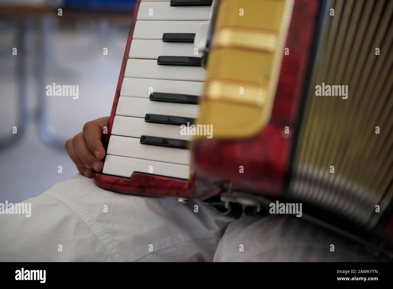 Ein Schüler übt im Rahmen des Musikschulprojekts "Ikarus" auf einem Akkordeon. Im Projekt der städtischen Gesangs- und Musikschule können Zweitklässler an der Grundschule Grafinger Straße über einen Zeitraum von zwei Monaten fünf verschiedene Musikinstrumente ausprobieren. [Automatisierte Übersetzung] Stockfoto