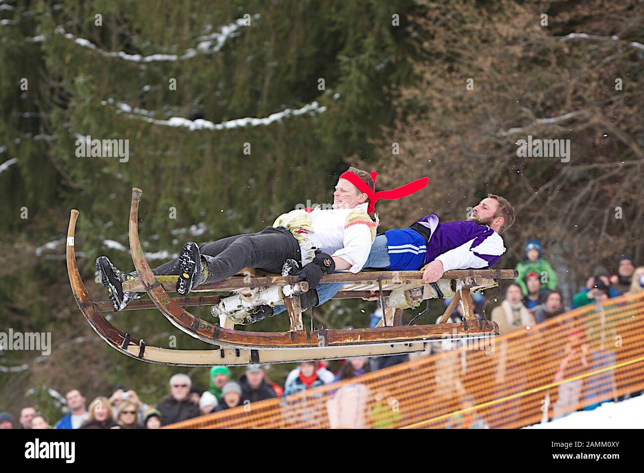 Ein Rennat's ist: Beim Gaißacher Schnablerrennen 2013 starteten 30 Schlitten und 70 Schnabler, im Bild Andreas Gerg und Georg Müller. Ziel des Rennens ist es, den 1,5 Kilometer langen, schmalen, steilen und teilweise eisigen Weg so schnell wie möglich hinunterzulaufen und dann möglichst auf dem natürlichen Hügel ohne mechanische Hilfsmittel wie Bremsen oder Lenkung zu fliegen. [Automatisierte Übersetzung] Stockfoto