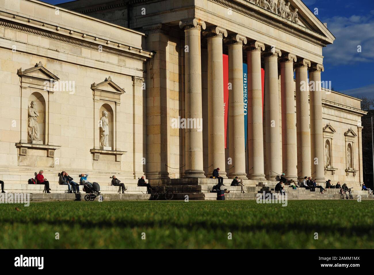 An einem milden Dezembertag nehmen die Besucher auf den Stufen der Glyptothek am Königsplatz ein Sonnenbad. [Automatisierte Übersetzung] Stockfoto