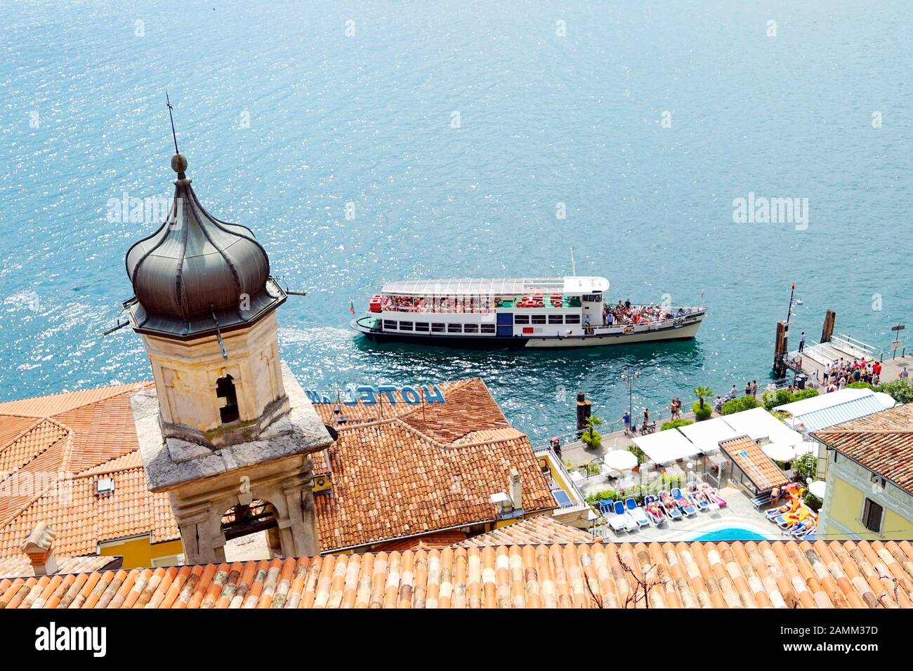 Die Kirche 'San Rocco' vor einem Ausflugsboot in Limone sul Garda am Westufer des Gardasee. [Automatisierte Übersetzung] Stockfoto