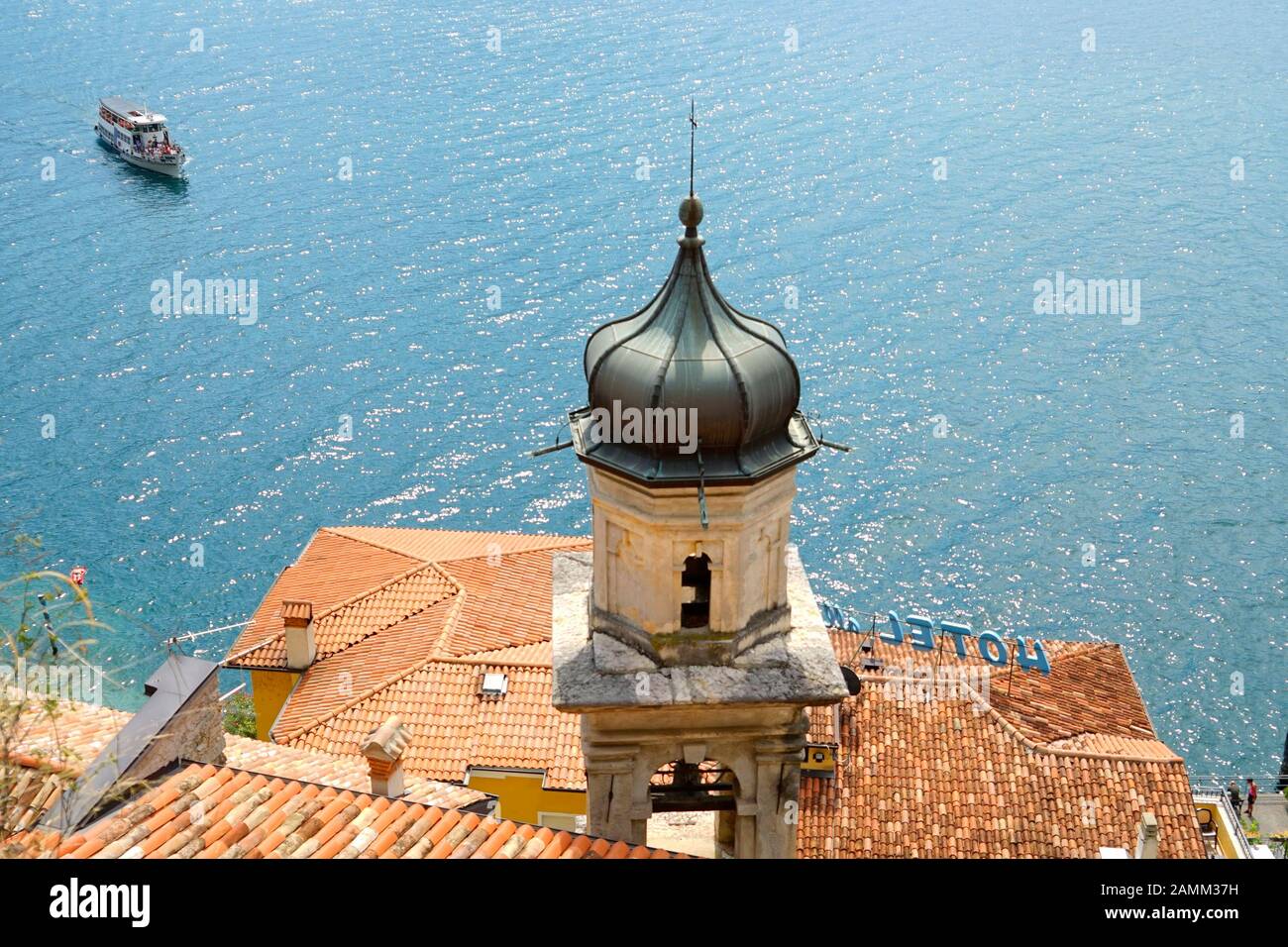 Die Kirche 'San Rocco' vor einem Ausflugsboot in Limone sul Garda am Westufer des Gardasee. [Automatisierte Übersetzung] Stockfoto