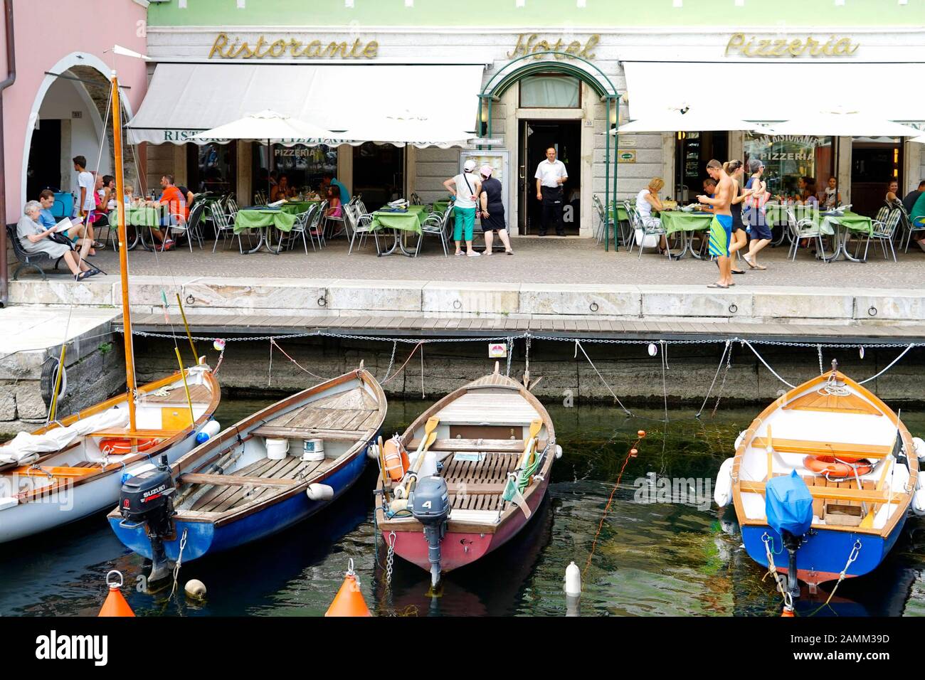 Boote vor einem Restaurant im Hafen von Torbole am Gardasee. [Automatisierte Übersetzung] Stockfoto