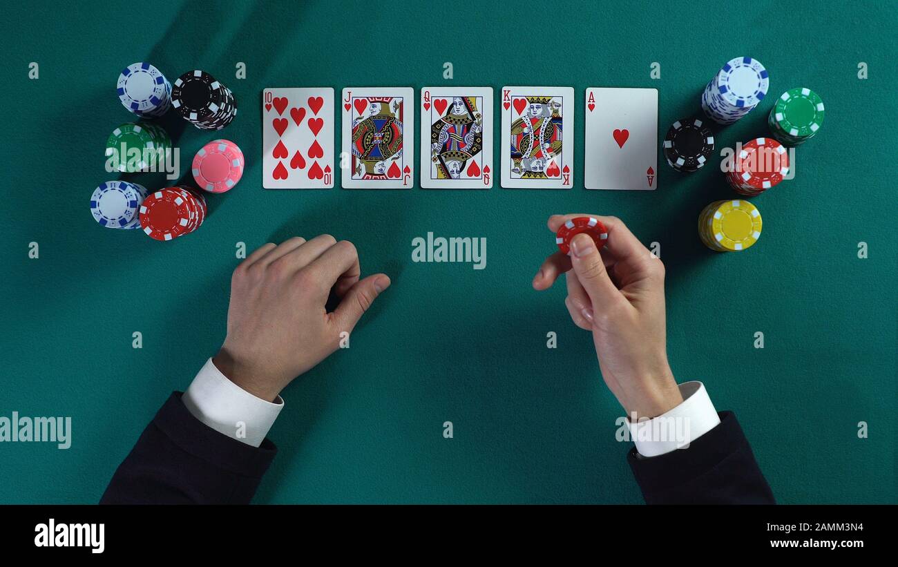 Lucky man hat Royal Flush Hand, gewinnt viel Geld im Pokerspiel und genießt Erfolg Stockfoto