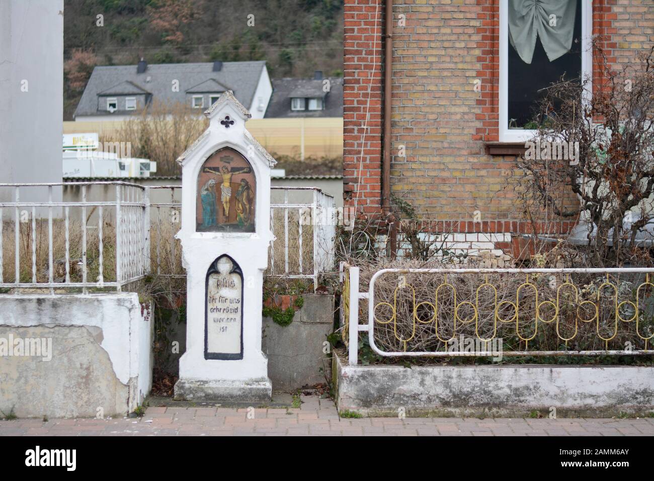 Ein Wegschrein mit Glasbruch steht in Kamp-Bornhofen im oberen Mittelrheintal. Unter dem gekreuzigten Jesus steht geschrieben: "Jesus, der für uns gekreuzigt wurde." [automatisierte Übersetzung] Stockfoto
