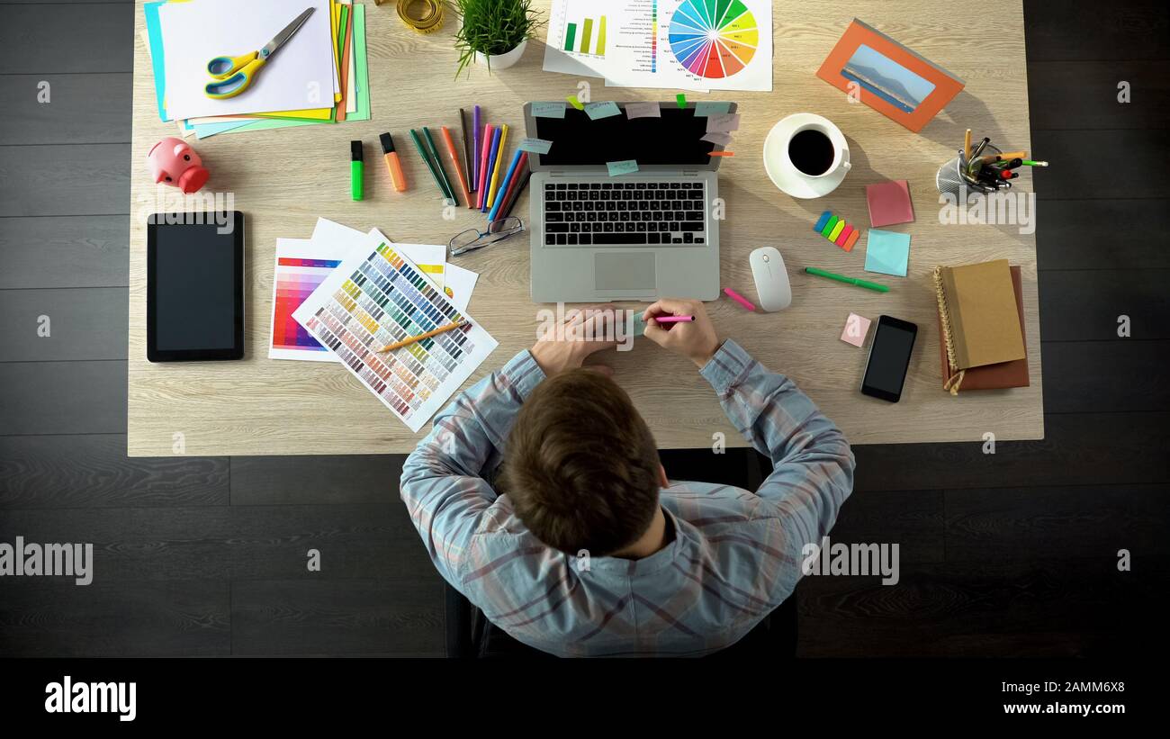 Inspirierter männlicher Schöpfer, der alle seine Ideen auf Papier aufschreibt, um sich daran zu erinnern Stockfoto