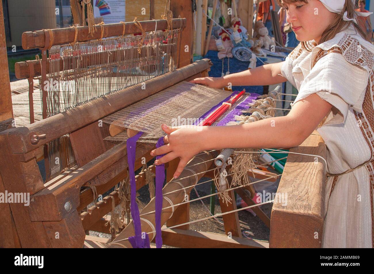 Der Weaver am Webstuhl - sie beendet einen gepunkteten Teppich [automatisierte Übersetzung] Stockfoto