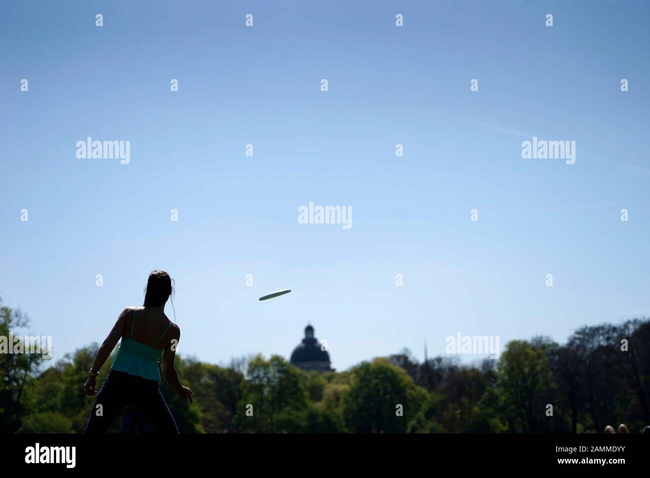 Eine Frau und ein Mann spielen an einem Frühlingstag im Englischen Garten mit einer Frisbee. [Automatisierte Übersetzung] Stockfoto