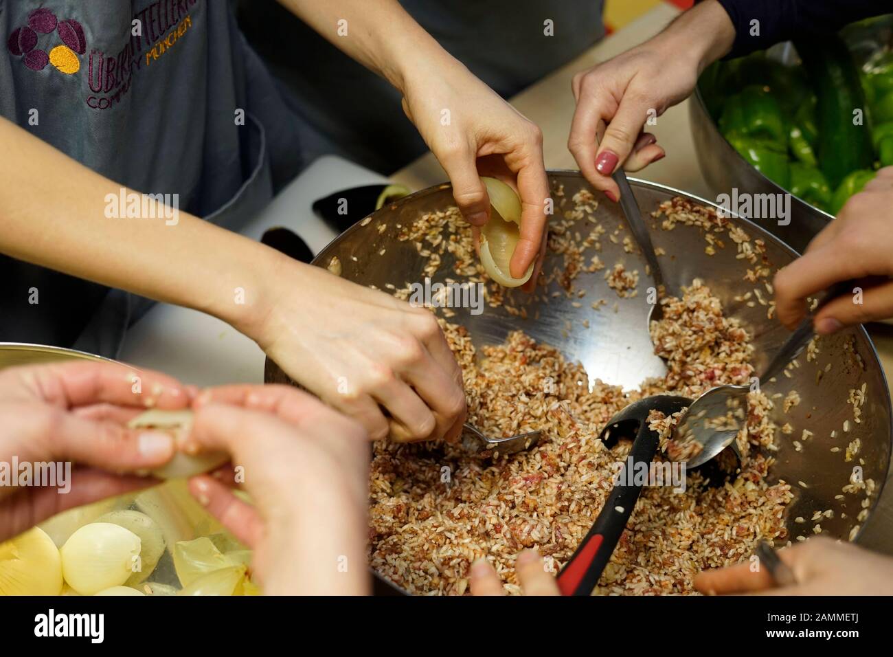 Bei der Kochveranstaltung des Vereins "Über den Rand" kochen und essen Einheimische zusammen mit Flüchtlingen im mehrgenerationenhaus im Münchner Stadtteil Milbertshofen/Am hart. [Automatisierte Übersetzung] Stockfoto