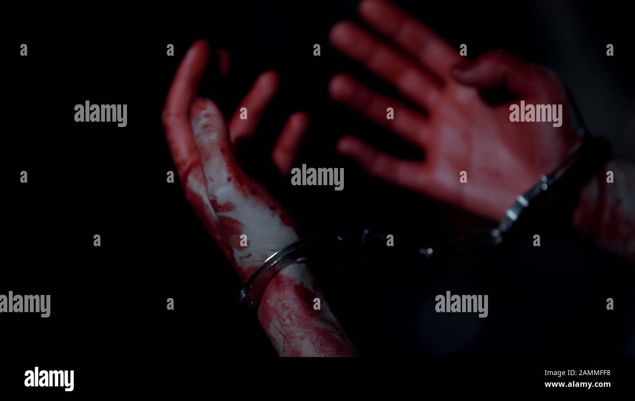 Verängstigte Person mit blutigen Handschellen, nachdem sie ein Verbrechen begangen hatte, Mörder Stockfoto