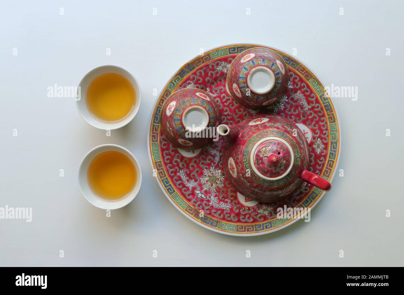 Vintage China Porzellan Teeset, Teekanne und zwei leere Tassen auf Untertasse, die anderen mit Tee gefüllt, die chinesischen Schriftzeichen bedeuten Langlebigkeit Stockfoto