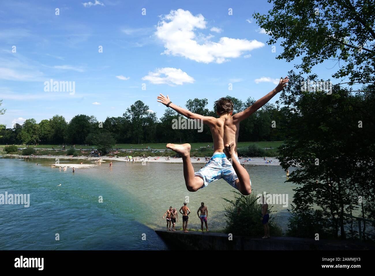 Ein junger Mann springt von der Brücke in der Hefner Alteneck Straße, nahe dem Roecklplatz, in die Isar. Besondere Vorsicht ist geboten, da das Wasser an dieser Stelle nicht tief genug ist. [Automatisierte Übersetzung] Stockfoto