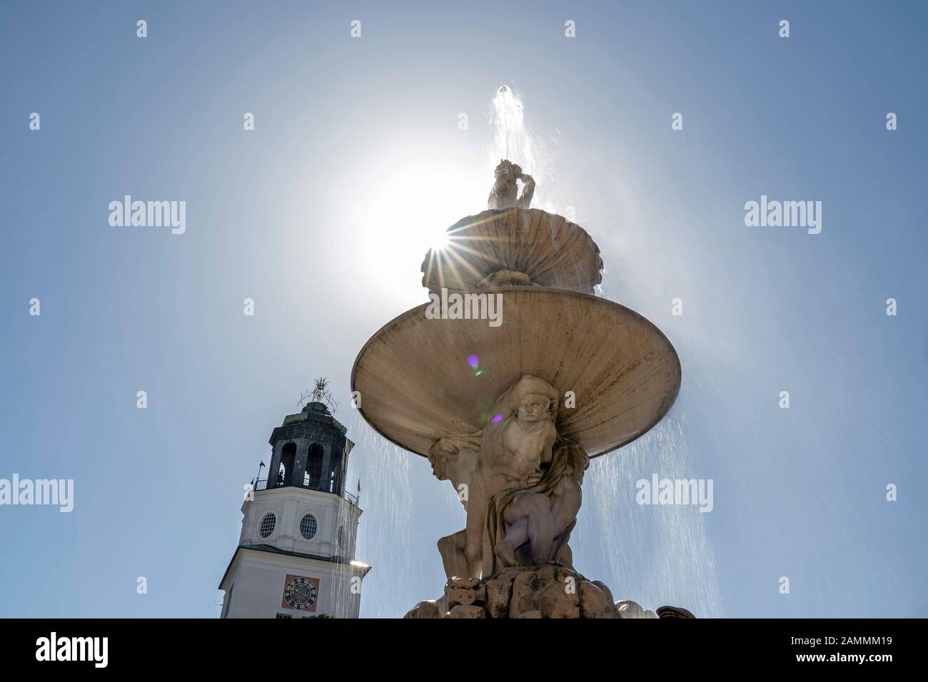 Die Sonne hinter dem Residenzbrunnen auf dem Residenzplatz vor dem Salzburger Dom [automatisierte Übersetzung] Stockfoto
