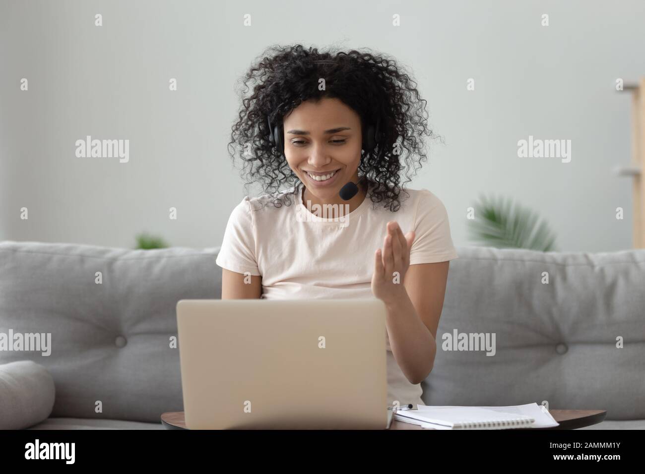 Afrikanerin trägt Kopfhörer mit Mikrofon, die online über Webcam chatten  Stockfotografie - Alamy