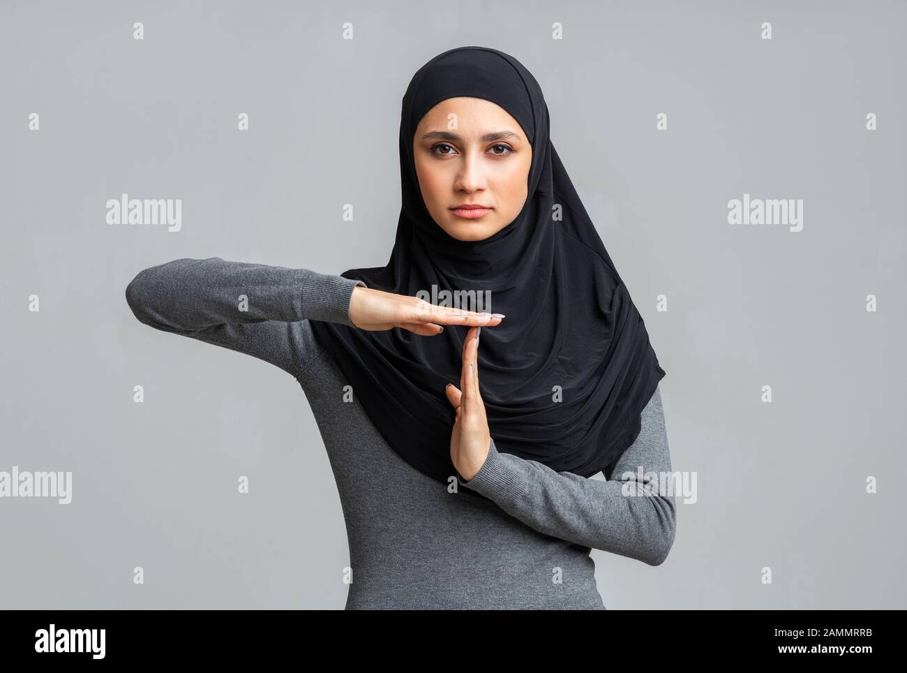Ernstes islamisches Mädchen zeigt Zeiterbrechen-Geste und zeigt ein Zeichen der Zeitpause Stockfoto